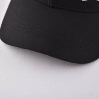 the-curved-brim-of-the-black-and-white-baseball-hat-at-front-left-side-KN2012232