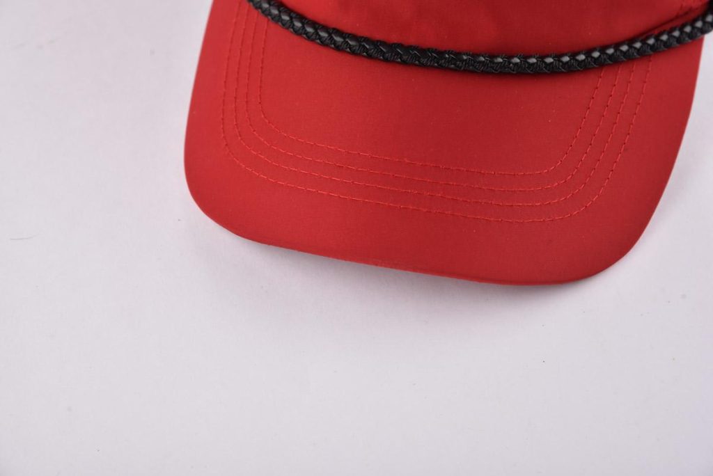 the curved brim of the red unisex baseball cap KN2012112
